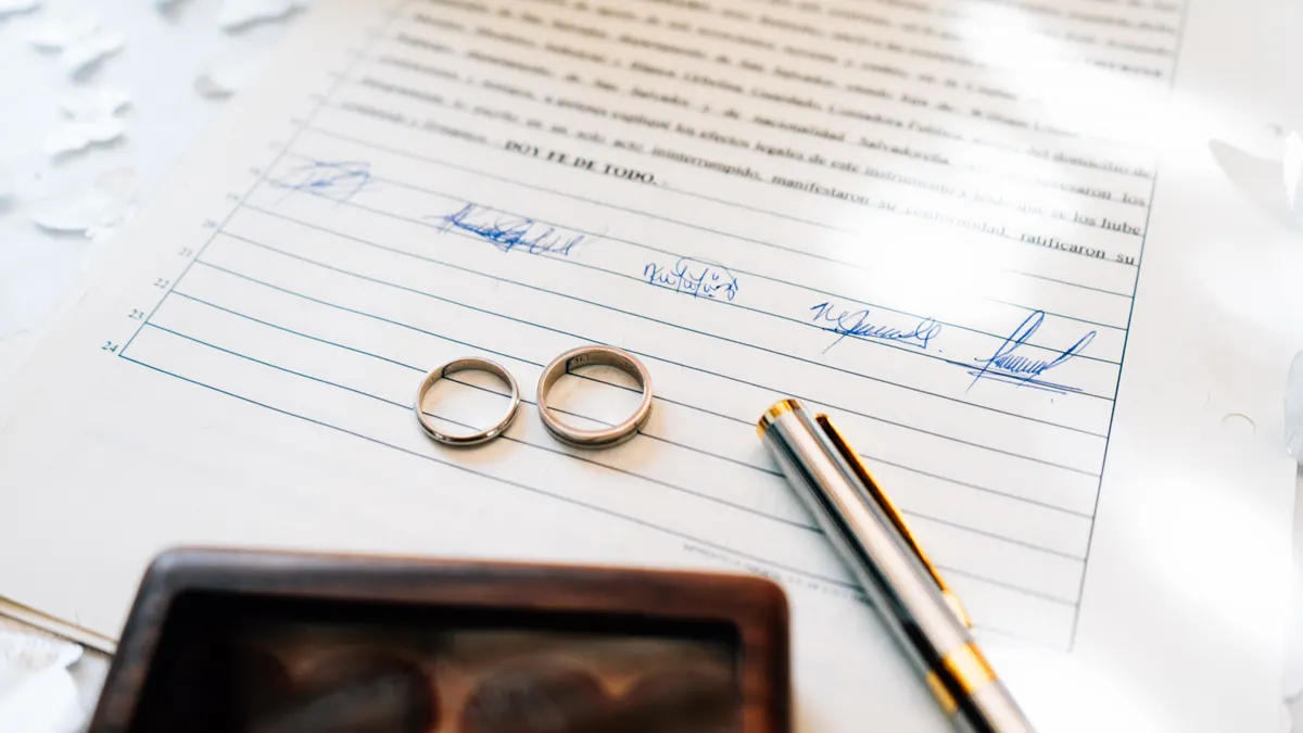 Alliances élégantes posées sur un certificat de mariage signé, symbolisant l'engagement.